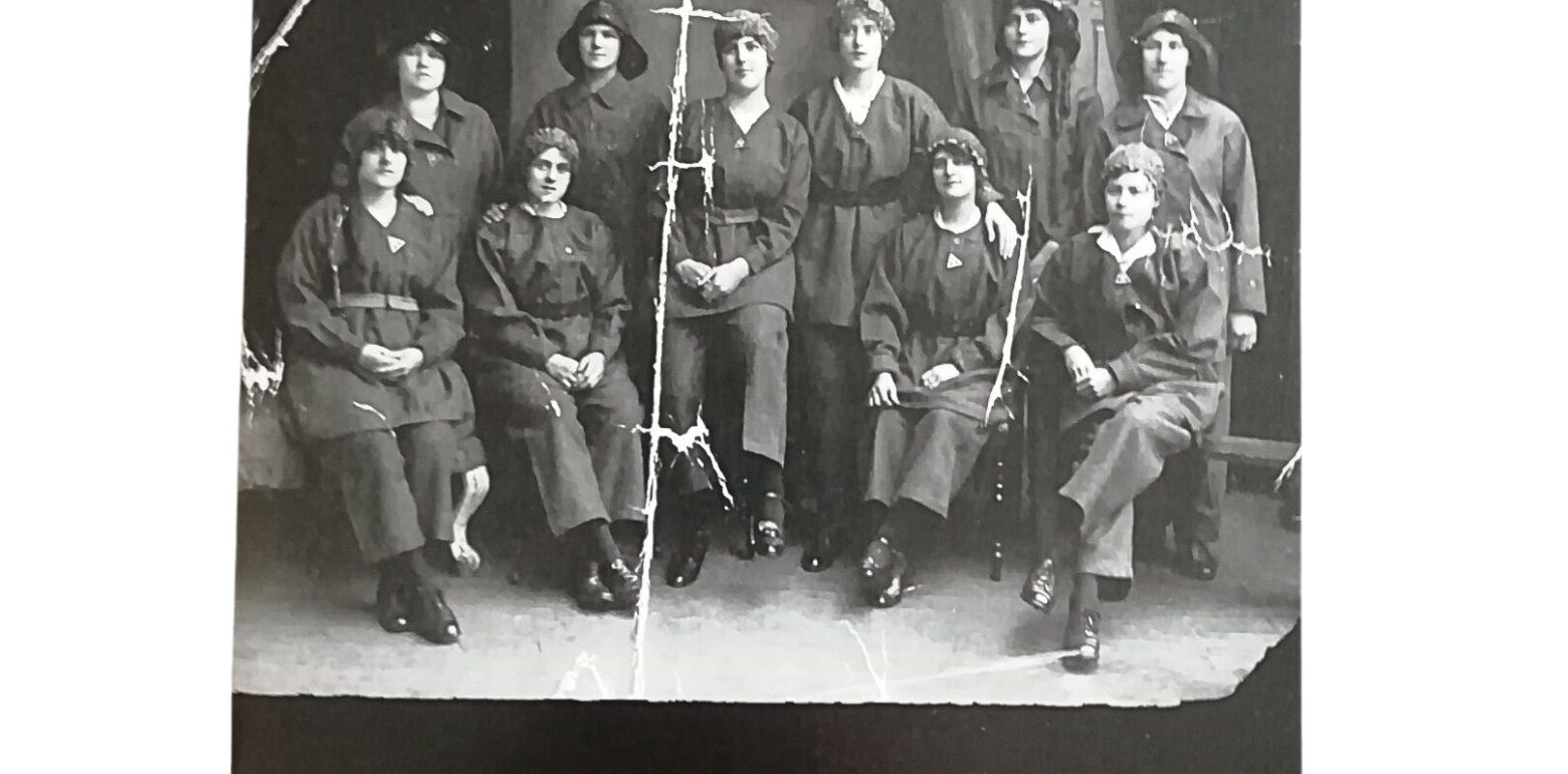 The front cover of 'Live of Ten Gretna Girls" book. It also features a archive photo of a group of munition workers in uniform.