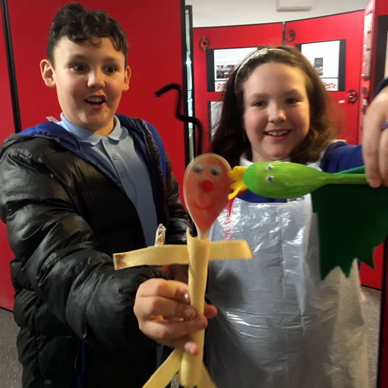 Some children with people they have made out of spoons at the museums Arts and Crafts club.