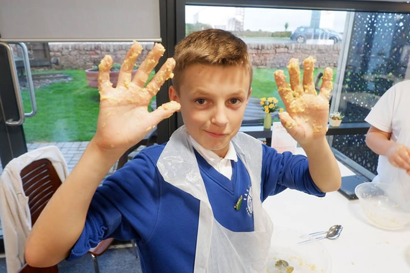 A child with messy hands at The Devil's Porridge Museum's Lets Bake club.