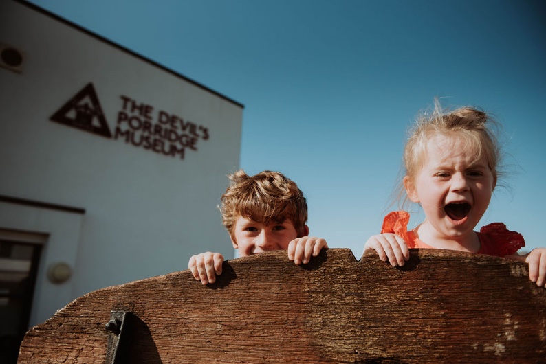 Two happy children outside The Devil's Porridge Museum.