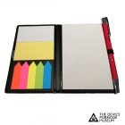 An open notebook with paper and small page markers inside. There is a red pen attached to one side of the notebook.