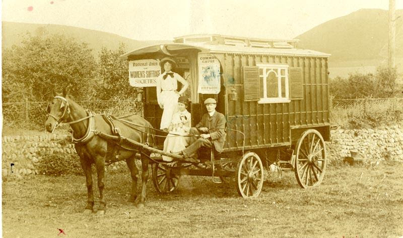 A horse pulled wagon with Hegla Gill on doing suffrage work.