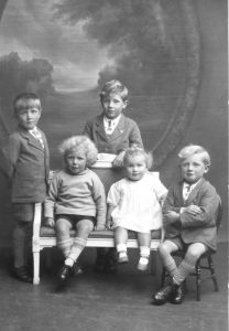 Five children stood and sat together. This is an archive photograph.