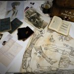Books, bandages and photos displayed on a table.