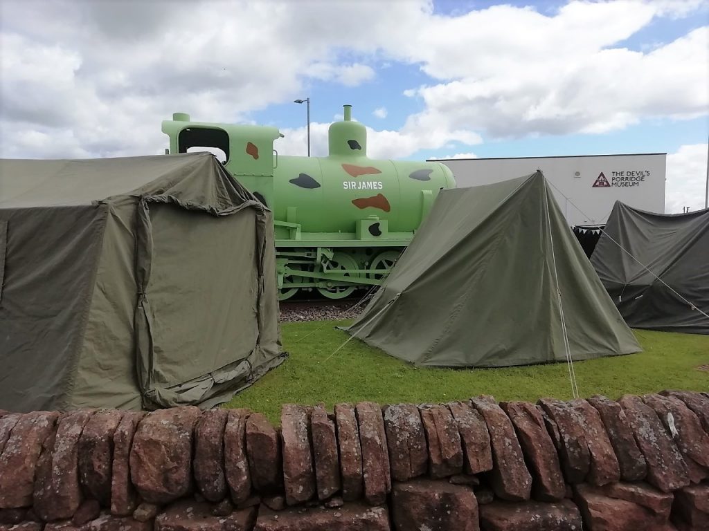 Some tents set up next to The Devil's Porridge Museum's fireless locomotive.