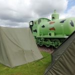 Sir James, the WW1 fireless locomotive with some tents set up beside next to him.