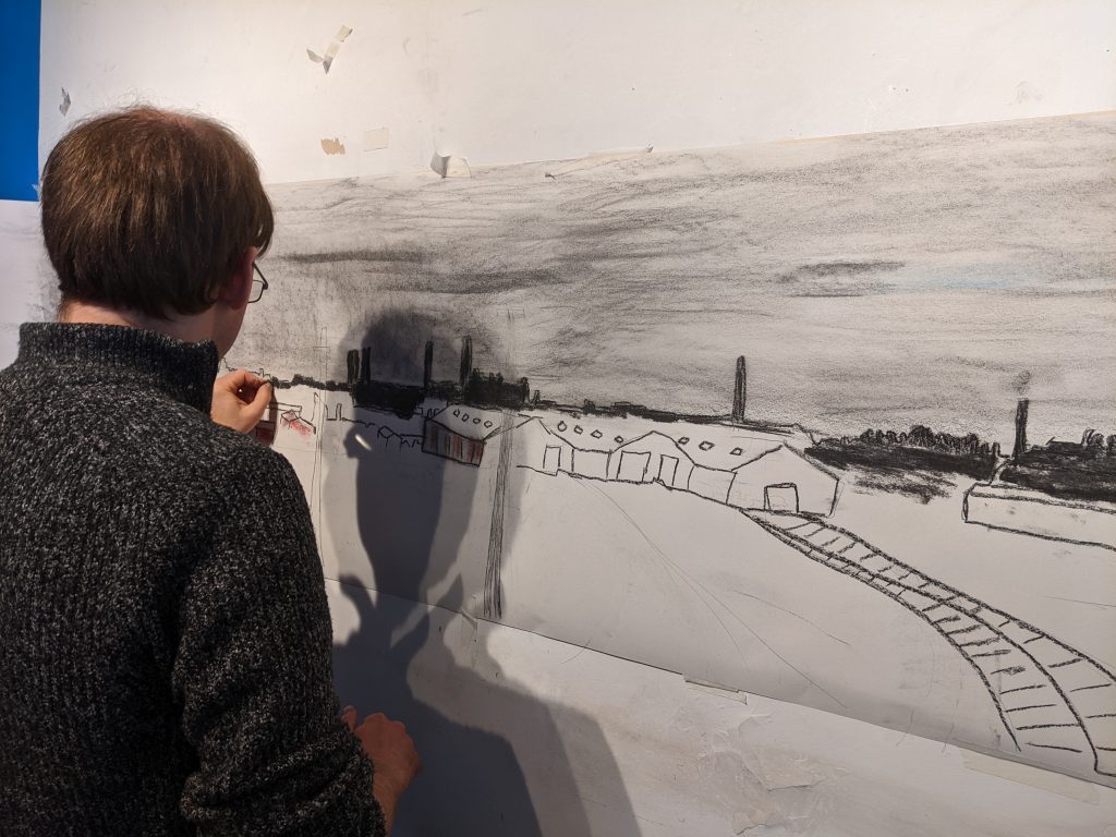 Someone drawing a panoramic landscape illustration, which is attached to a wall.