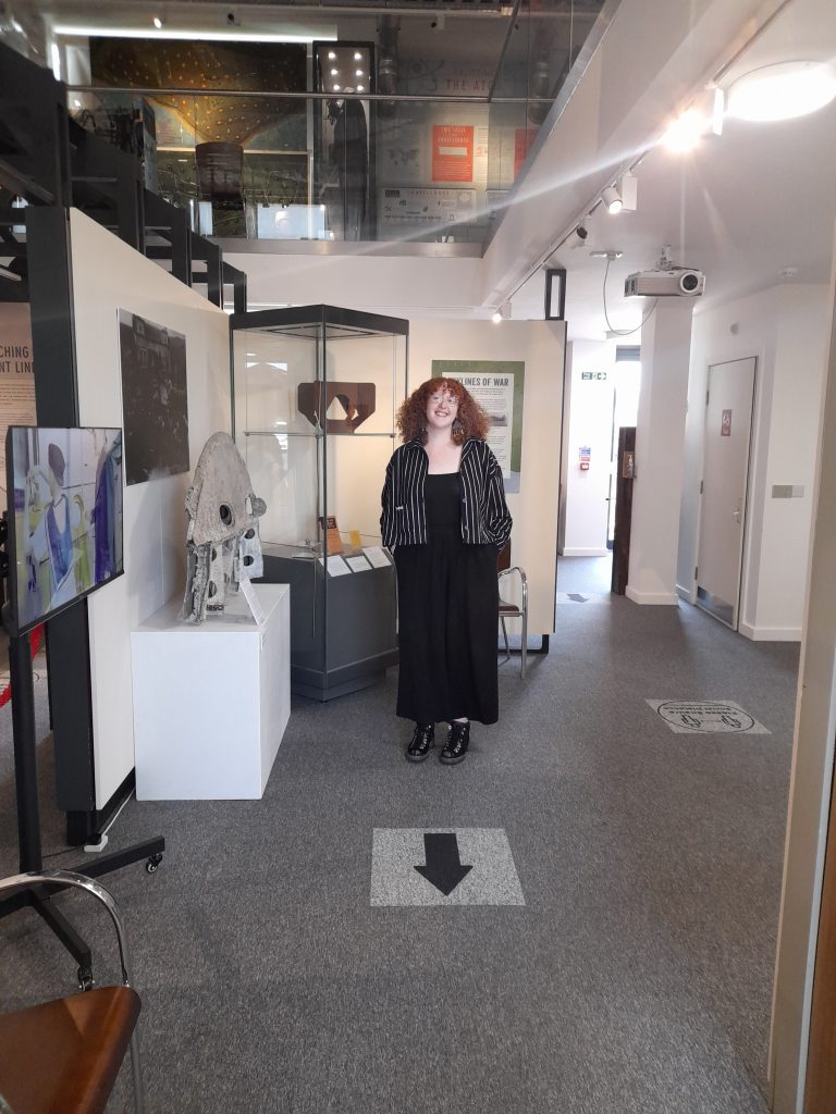 A person stood in the temporary exhibition area of The Devil's Porridge Museum.