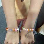 Two colourful bracelets worn by a child.