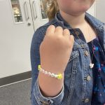 A handmade bracelet on the arm of a child.