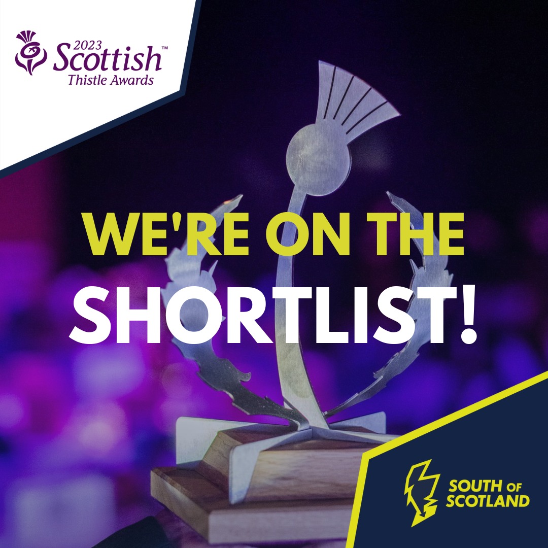 An photo of a metal award in the shape of a thistle with the words 'We're on the Shortlist!'. The logo for the Scottish Thistle Awards is in the top left corner and South of Scotland is writtend in the lower right corner.