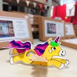 A unicorn glider with some cardboard craft kits blurred in the background. This was made by the Scotia Crafters.