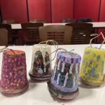 Four handmade birdfeeders painted with colourful designs.