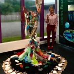 Artist Gail McGregor stood next to a sculpture she made out of upcycled materials.