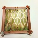 A small photo frame handmade out of wooden popsicle sticks.