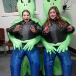 Two girls wearing inflatable alien costumes.