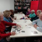 A table of retirees playing card games together in The Devil's Porridge Museum's Cordite Club.