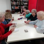 Some members of the Cordite Club sat at a table playing a beetle drive game.