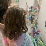 Children looking at a sculpture made out of upcycled materials.