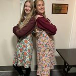 Two ladies dressed in 1940s style aprons.