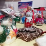 Some festive tombola prizes. These include a snowman figure, a bag and some Christmas colouring in.