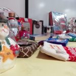 An assortment of tombola prizes with labels stuck on them for the winners. They include a snowman figure and some Christmas stockings.