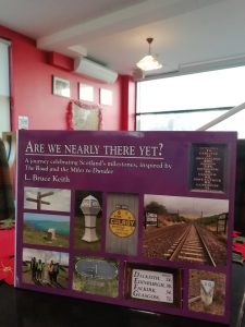 A purple rectangle shaped book with the title "Are we nearly there yet?" The Devil's Porridge Museum's Café can be seen in the background.
