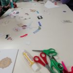 A table with some glue, scissors and other craft supplies on.