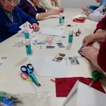 Some people creating calendar cards at a table.