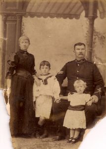 A black and white photo of a family from the past. From left to right is Catherine Reardon, Francis Thomas McLintic as a boy, his father Francis James McLintic and his young daughter Winifred Maud McLintic.