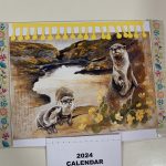 A card with an illustration of two otters and a calendar on.