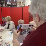 A member of The Devil's Porridge Museum holding a card with a calendar on.