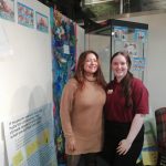The museum's Youth and Community Engagement Officer and a Museum Assistant in the temporary exhibition area. They look happy.