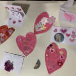 Handmade Valentines cards and hearts on a table.