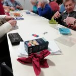 Some members of the museum's Cordite Club sat at a table making Easter baskets. There are also some biscuits on the table.