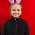 A child wearing a headband with some rabbit ears on.