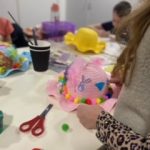 A child holding the Easter bonnet they are making.