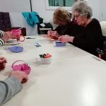 Some members of the museum's Cordite Club sat at a table making Easter baskets.