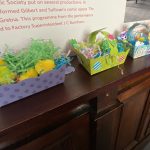 Four small Easter baskets, which are full of Easter chicks and paper.