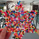A star coater made out of Hama beads in The Devil's Porridge Museum with the Mossband clock in the background.