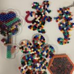 Two flowers, a hexagon, a seahorse and a mouse made out of Hamah beads.
