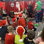 Children sat on the floor in front of Santa.