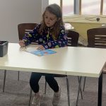A young person drawing at The Devil's Porridge Museum's Mostly Ghostly event.