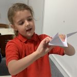 A young person making an origami craft.