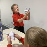 A young person leading an origami Arts and Crafts club session at The Devil's Porridge Museum.