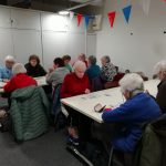 Some members of The Devil's Porridge Museum's Cordite club sat around two tables.