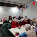 Some of The Devil's Porridge Museum's Cordite Club sat around some tables playing cards.