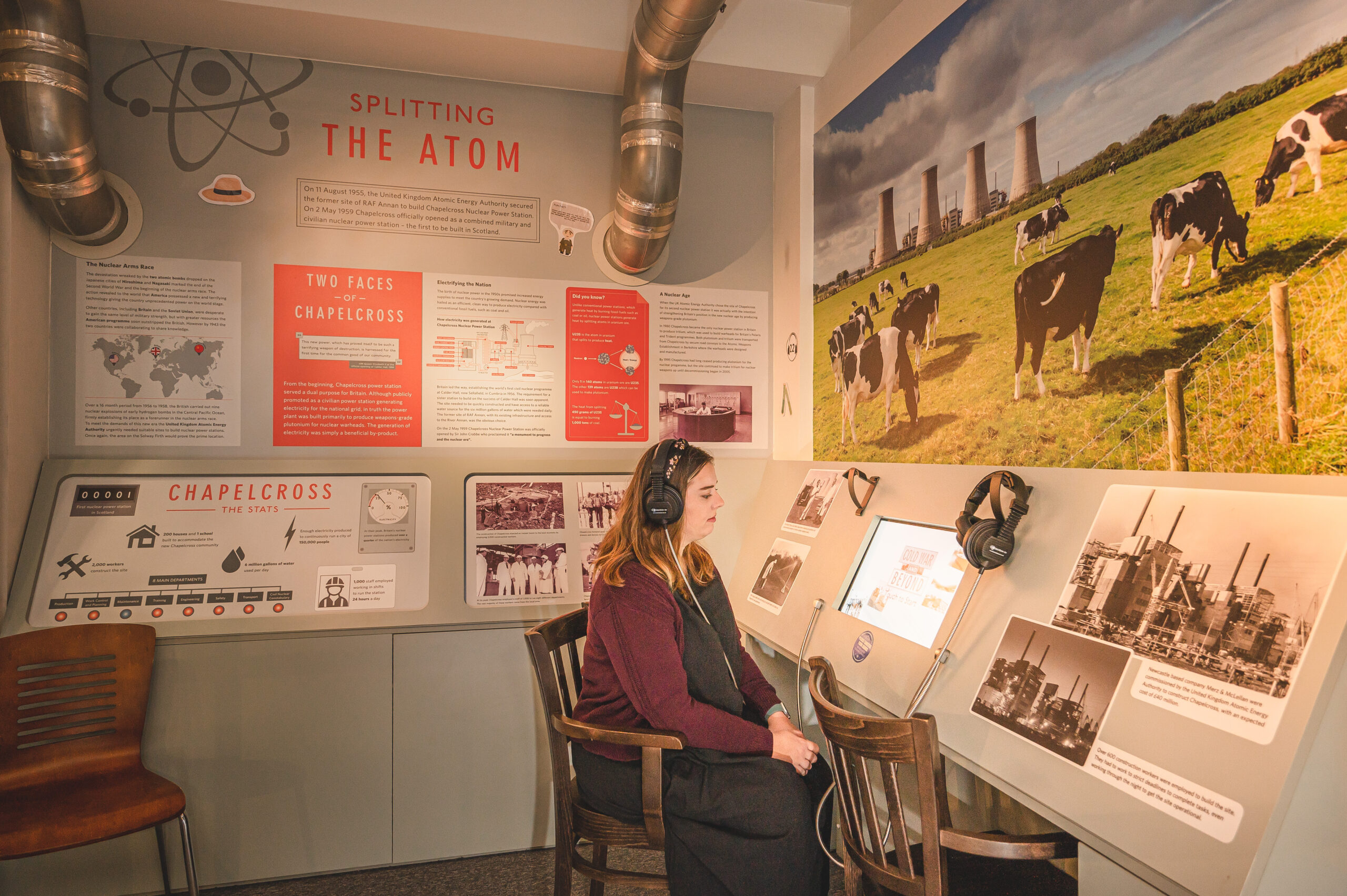 A visitor sat listening to a video in the Chapelcross section of The Devil's Porridge Museum.