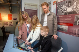A family at the Chapelcross control panel section of The Devil's Porridge Museum.