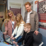 A family at the Chapelcross control panel section of The Devil's Porridge Museum.